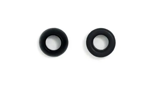 A pair of black ear studs on a white surface.