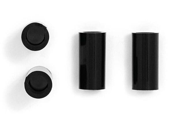 Three black plastic tubes on a white surface.