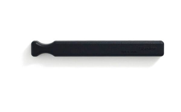 A black plastic tool on a white surface.