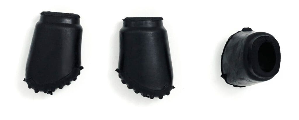 A pair of black rubber shoe covers on a white surface.