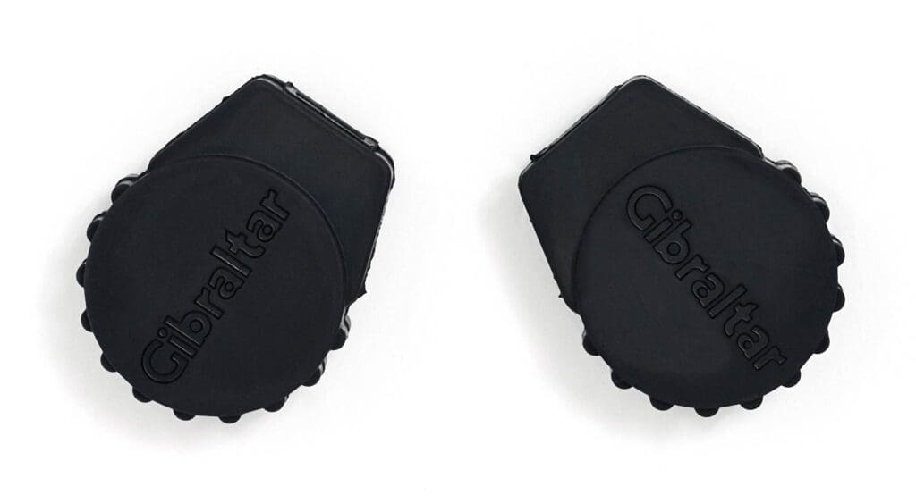 A pair of black plastic caps on a white surface.