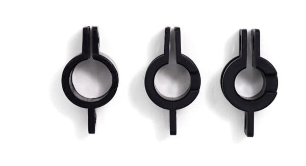 Three black metal hooks on a white surface.