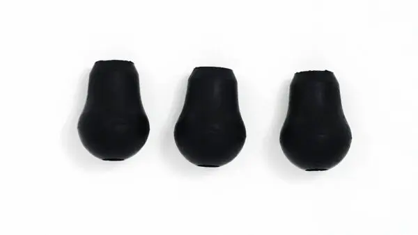 Three black plastic plugs on a white surface.