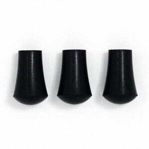 Three black plastic plugs on a white surface.