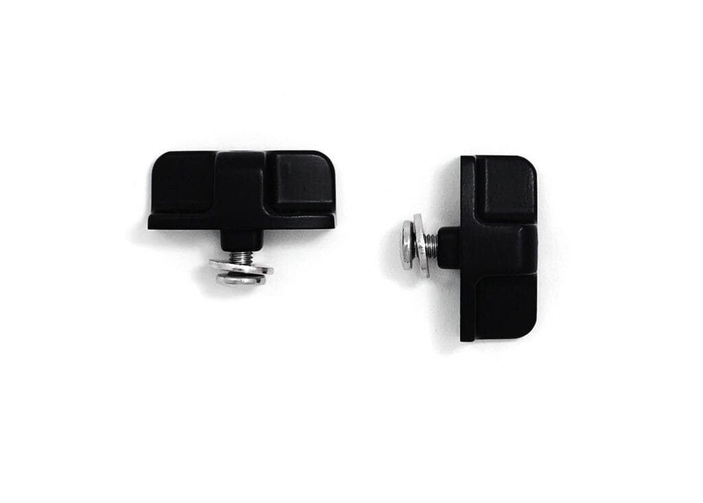 A pair of black plastic clamps on a white surface.