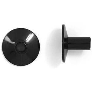 A pair of black plastic knobs on a white surface.