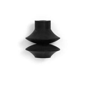 A black vase sitting on top of a white wall.