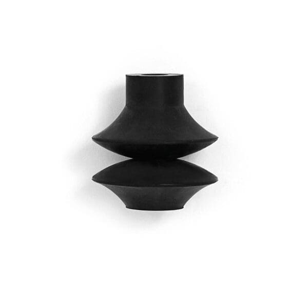 A black vase sitting on top of a white wall.