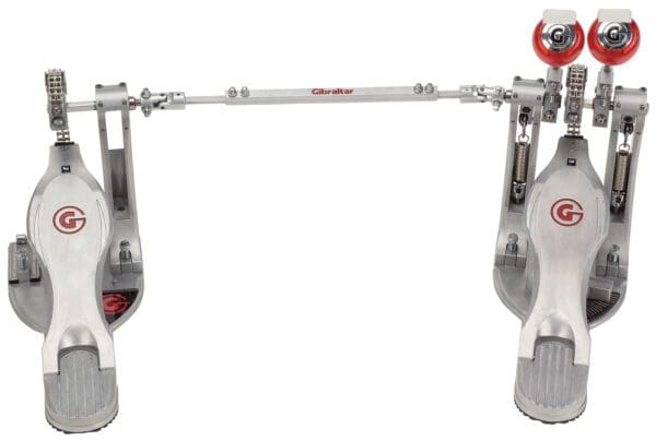 A metal drum pedal with a red knob.