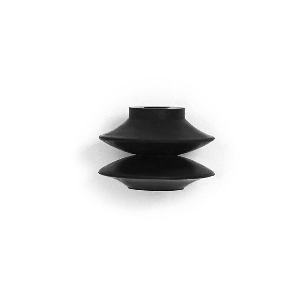 A black vase sitting on top of a white surface.